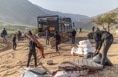   תושבים בראס עין אל-עוג'א מעמיסים חלקי מבנים שפורקו על משאית לקראת עזיבה. צילום: אבישי מוהר, בצלם, 8.1.26 