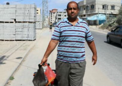 <br />
<br />
<br />
Muhammad Dahlan, dragging the cooler containing the slush puppies he sells. Photo by Khaled al-'Azayzeh, B'Tselem, 26 Sept. 2017<br />
<br />
<br />
