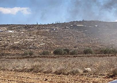 תושב תורמוסעיא משקיף על העשן מהמכונית שהוצתה ו"החווה החקלאית" שהקימו מתנחלים. התמונה באדיבות העדים