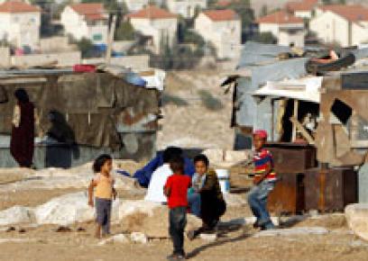 أطفال من قبيلة الجهالين وفي الخلفية مستوطنة معاليه أدوميم. إسرائيل تخطط لطرد سكان القرى البدوية من المنطقة لغرض توسيع المستوطنة. تصوير: عمار عواد، رويترز، 16 حزيران 2012.