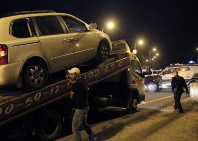 Man stands next to a car with bullet holes at the scene of a shooting near the West Bank city of Hebron April 14, 2014. Photo: Ammar Awad, Reuters