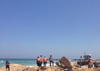 חיפוש גופות בחולות למחרת ההפצצה. צילום: פארס אכרם, 10.7.14