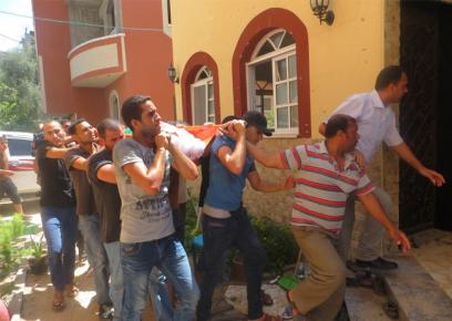 גופת אחד ההרוגים בהפצצת בית משפחת חמד מוכנסת לבית המשפחה, לקראת מסע הלוויה. צילום: מוחמד סבאח, 9.7.14