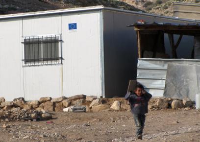 ילד על רקע אחד המגורונים של קהילת אל-כעאבנה. צילום: עאמר עארורי, בצלם, 18.1.15.