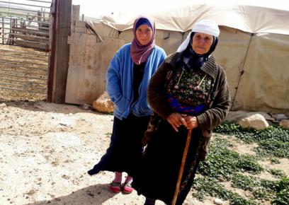 زينب ورسمية أبو عرّام، الأم وابنتها، بجانب حظيرة لهنّ في خربة جنبا. تصوير: أوسنات ساكوبلينسكي، بتسيلم.