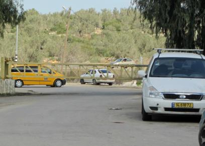 سيارة أجرة تنتظر مسافرين خارج البوابة المغلقة عند مدخل عزون الرئيسيّ. تصوير: عبد الكريم السعدي، بتسيلم، 2.2.17.