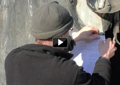 Civil Administration worker posting a stop-work order on a Khan al-Ahmar structure. Still from footage by B’Tselem field researcher Hussam ‘Abed, 19 Feb. 2017