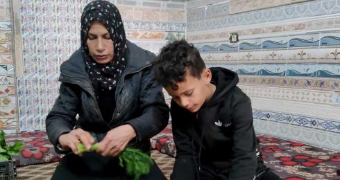 ُلا كريم وأحد أبنائها يحضّران البضاعة لبسطة الخضار. تصوير: ألفت الكرد، بتسيلم، 28.3.23