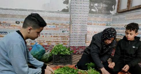 ُلا كريم واثنان من أبنائها يحضّرون البضاعة لبسطة الخضار. تصوير: ألفت الكرد، بتسيلم، 28.3.23