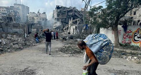  أحد سكان حيّ الرمال المُدمَّر في مدينة غزة نازحاً يحمل بض أمتعته. تصوير: محمد صباح، بتسيلم