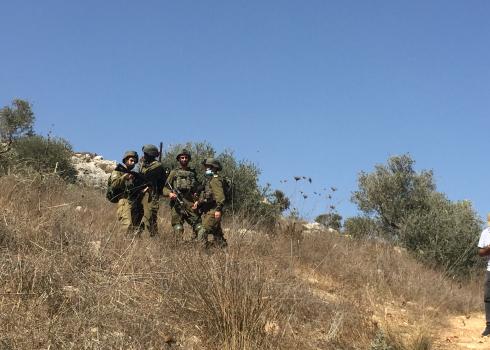 Soldiers accompanying settlers who attacked harvesters in Huwarah, 7 Oct. 2020. Photo by Dina Chizhik, B’Tselem. 