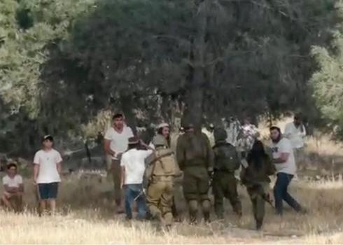 Settlers and soldiers in wooded area near a-Tuwani. 