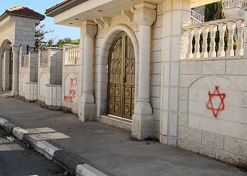 הכתובת "כאן גרים אויבים" ומגן דוד אדום שריססו מתנחלים על גדר האבן של בית. צילום: איאד חדאד, בצלם, 9.11.21 