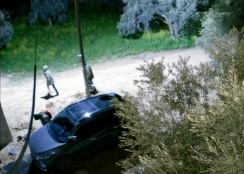A settler punctures car tires as others retreat. Still image from footage 