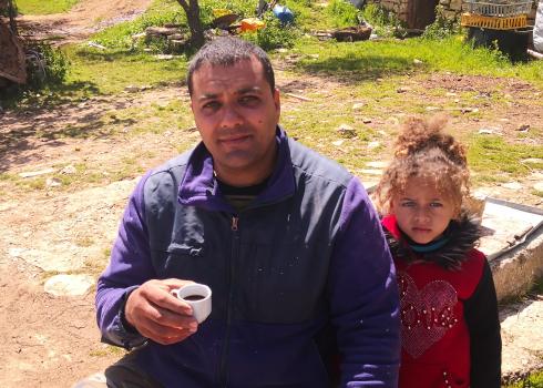 Bilal Khalil with his daughter in their yard. Photo: Iyad Hadad, B’Tselem, 28 March 2022 