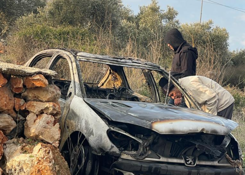 יוסף סלאח ואחד מבני משפחתו בוחנים את המכונית ששרף המתנחל. התמונה באדיבות סלאח 