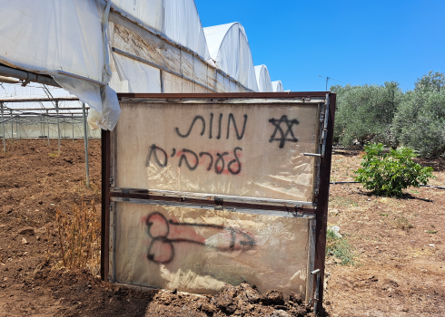 The slogans settlers graffitied on the greenhouse. Photo: Abdulkarim Sadi, B’Tselem, 25 June 2023 