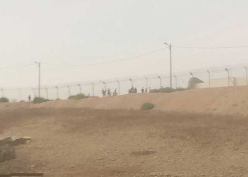 The settlers standing behind the fence. Photo courtesy of local residents
