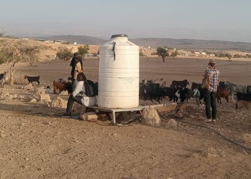 مستوطنون مع قطيع بجانب خزان مياه خاص بسكان التجمع. صورة قدمها السكان مشكورين، 26.10.25