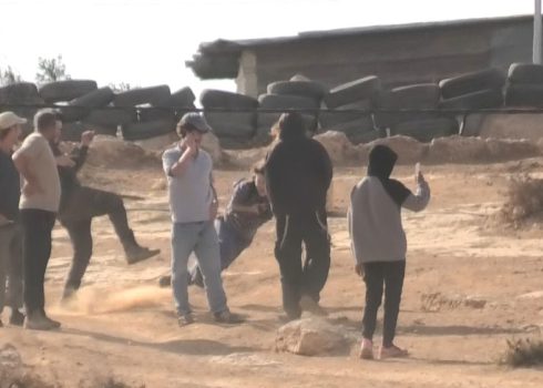 The settler kicking the activist and knocking her down. Photo courtesy of local residents 