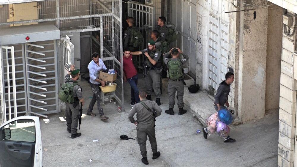 Israeli Border Police do not allow Hebron family to transfer their possessions by truck, forcing them to move house via a checkpoint. Stills from B'Tselem Camera Project video footage, 7 July 2017