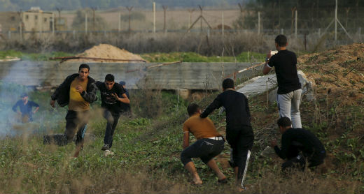 Palestinian protesters flee Israeli gunfire during protest near the Gaza Strip perimeter fence east of Gaza City. Photo by Mohammed Salem, Reuters, 20 Nov. 2015