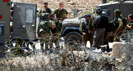 חיילים עומדים לאחר האירוע ליד קטע מגדר התיל שבה ניסה חאמד לפתוח פתח. צילום: מוחמד תורכמן, רויטרס, 26.8.16.