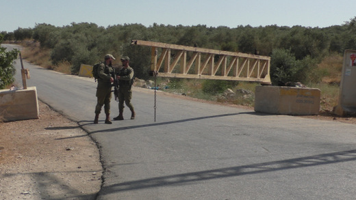 Soldiers stand beside the gate installed by the military at the main entrance to the village. Photo by 'Amer 'Aruri, B'Tselem, 19 June '17 Soldiers stand beside the gate installed by the military at the main entrance to the village. Photo by 'Amer 'Aruri, B'Tselem, 19 June '17