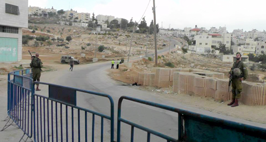 הרחוב הראשי בשכונת א-נסארא, השמור למתנחלים בלבד. מימין: הגדר, שמאחוריה נדרשים פלסטינים ללכת בשדה טרשים. צילום: מנאל אל-ג'עברי, בצלם, יוני 2017