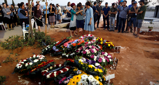Mourners by the graves of the three members of the Solomon family. Photo by Ronen Zevulun, Reuters, 24 July 2017 Mourners by the graves of the three members of the Solomon family. Photo by Ronen Zevulun, Reuters, 24 July 2017