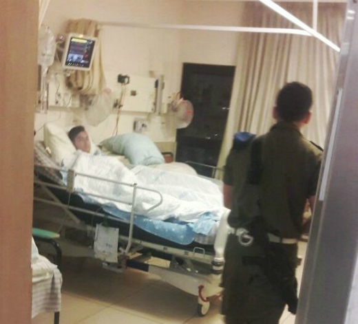 N.R. being guarded by a soldier at hospital. Photo taken by his mother on her mobile phone, as she sat outside and was not allowed into the room. N.R. being guarded by a soldier at hospital. Photo taken by his mother on her mobile phone, as she sat outside and was not allowed into the room.