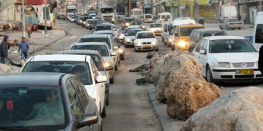הפקק לפני מחסום קלנדיה, 05:50 בבוקר. תושבי שכונות שנותרו מעבר לגדר ירושלים בדרכם לעבודה בעיר. צילום: עאמר ערורי, בצלם, 19.3.14